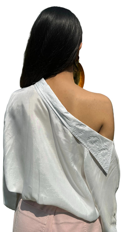 Woman wearing a white off-shoulder top in an outdoor setting