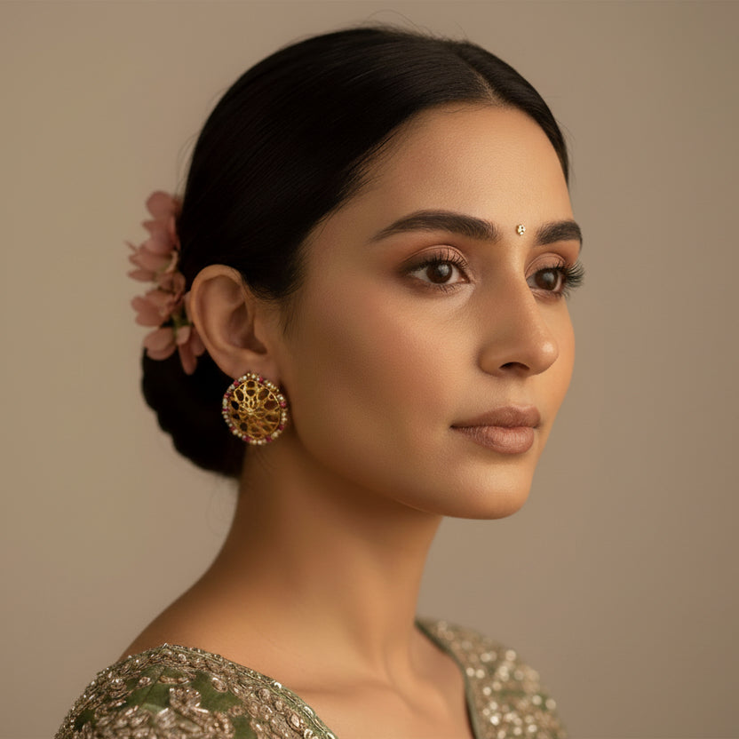 Woman wearing traditional attire with gold jewelry against a neutral background