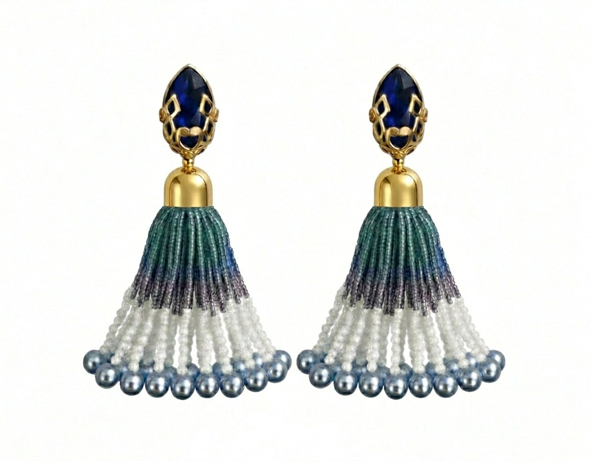 Pair of tassel earrings with blue and gold accents on a white background