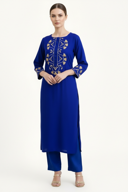 Woman wearing a blue dress with gold embroidery on a white background