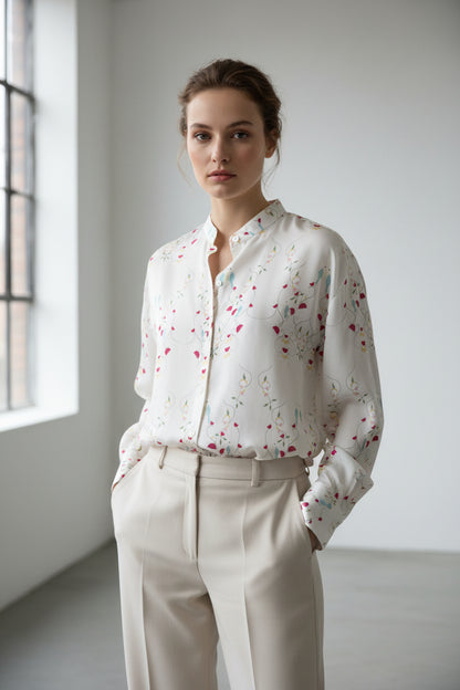 White blouse with colorful floral pattern on a mannequin against a white background